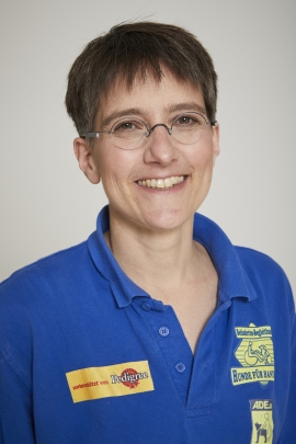 Sabine Häcker Hier ist das offizielle Bewerbungsfoto von Sabine Häcker für die "Bild der Frau". Wir sehen eine lachende Sabine im blauen T-Shirt von HfH. Sabine hat einen flotten Kurzhaarschnitt und sie trägt eine runde Brille mit Halbrand.